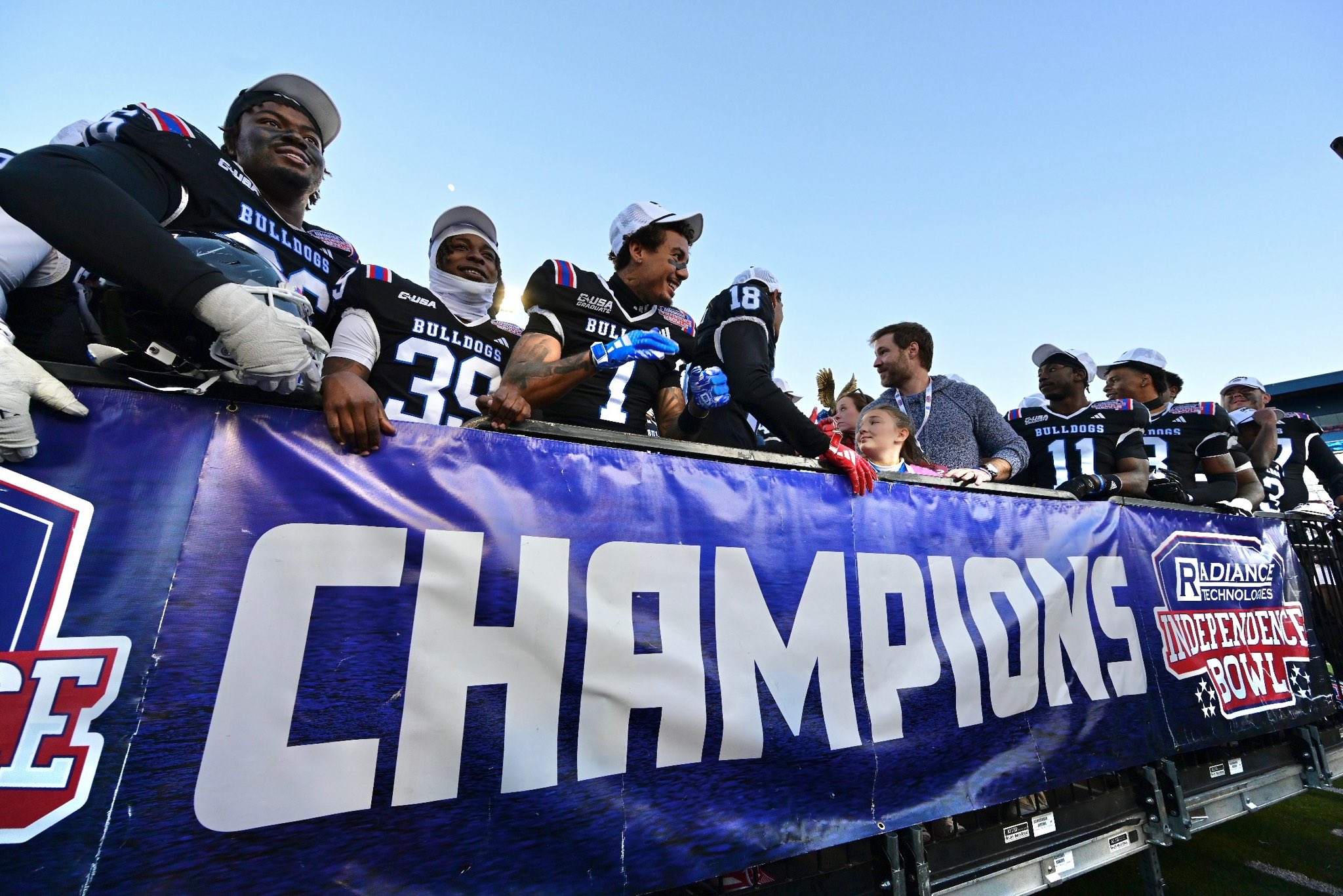 Blue Bloods members with a bowl champion banner